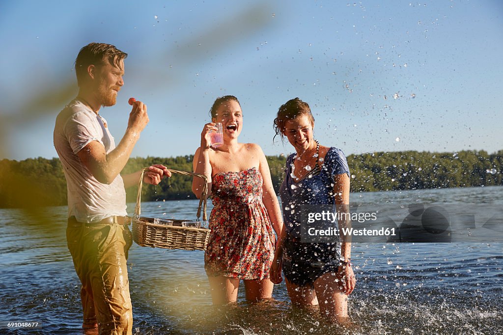 Playful friends splashing in a lake taking a drink