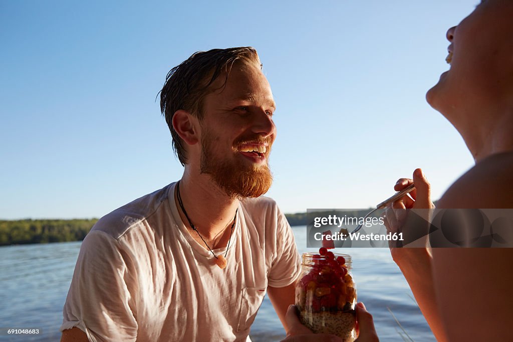 Happy couple at a lake taking a healthy snack