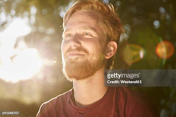 smiling young man in backlight outdoors - summer lights stockfoto's en -beelden