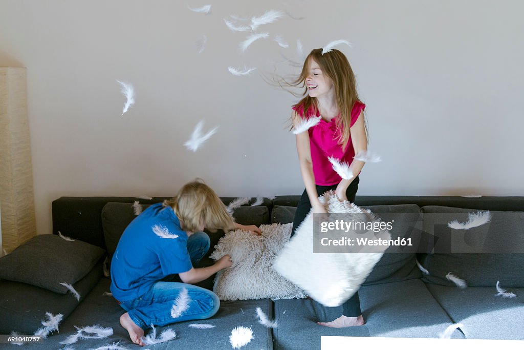 Pillow fight between brother and sister at home