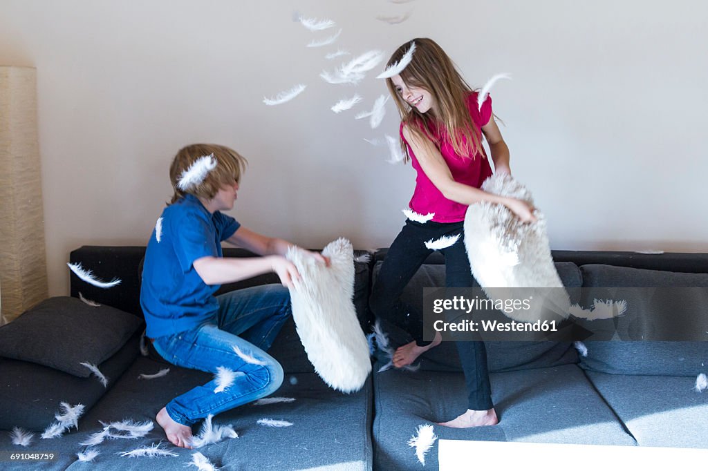 Pillow fight between brother and sister at home