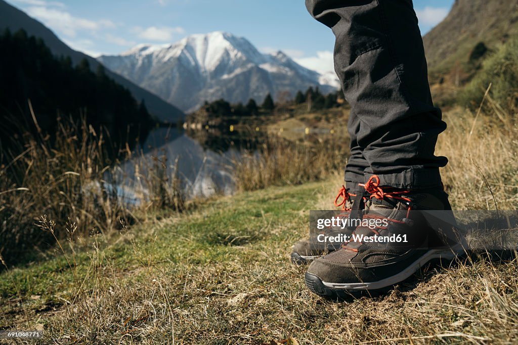 France, Pyrenees, Pic Carlit, close-up of hiker taking a rest at mountain lake