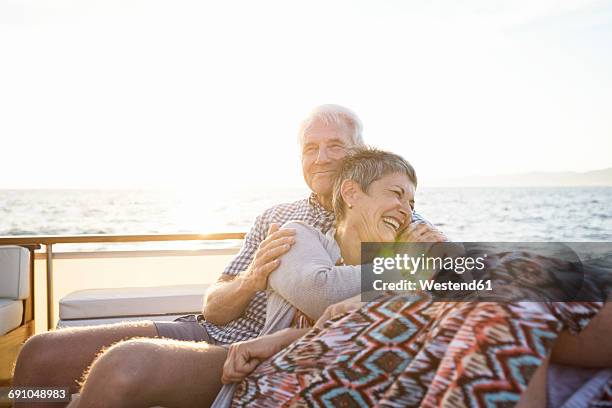 affectionate couple on a boat trip at sunset - rijkdom boot stockfoto's en -beelden