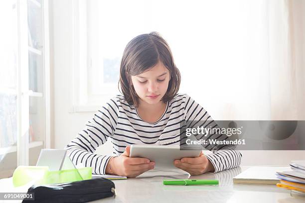 girl doing homework with tablet - homework table stock pictures, royalty-free photos & images