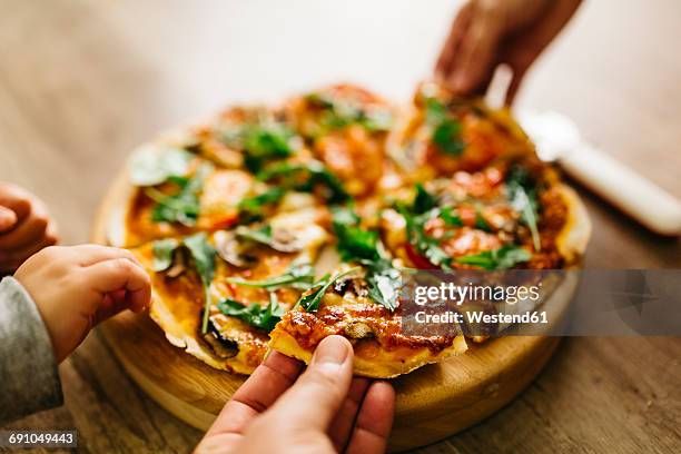 hands picking up pizza slices - casa sezione foto e immagini stock