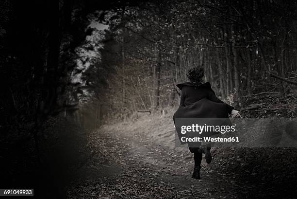 back view of woman running on forest track - runaway 個照片及圖片檔