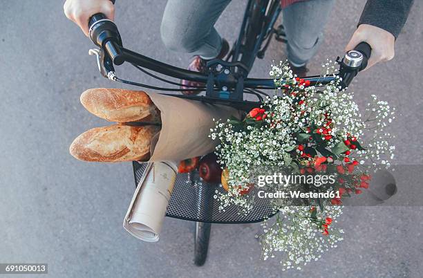 man with apples, bouquet of flowers, newspaper and baguettes in bicycle basket - bike flowers stock pictures, royalty-free photos & images