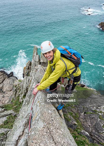 uk, cornwall, smiling woman climbing on commando ridge - freiklettern stock-fotos und bilder