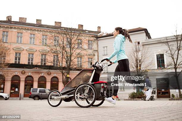 Mother running with child in stroller in the city