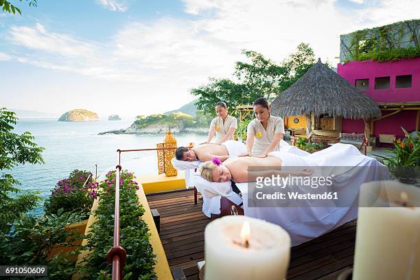 luxury vacation with massage on ocean front terrace - massage couple stock pictures, royalty-free photos & images