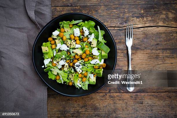 bowl of leaf salad with roasted chick-peas, avocado, feta and black sesame - chick pea salad stock pictures, royalty-free photos & images