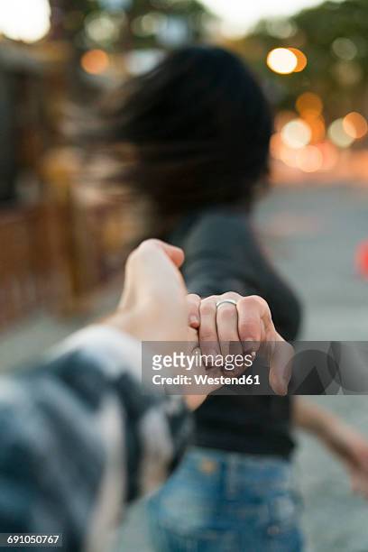 couple in motion hand in hand outdoors - haare schütteln stock-fotos und bilder