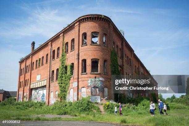 Family take a short cut from the shops past the derelict Great Northern Railway Bonded Warehouse on May 31, 2017 in Derby, England. The Derby North...