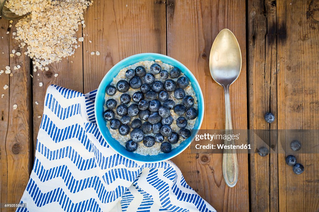 Bowl of overnight oats with blueberries on wood