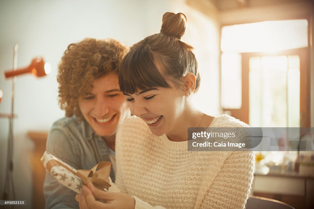 Smiling young couple opening birthday gift