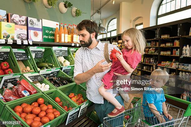 father with daughter and son shopping organic food - leanintogether stock pictures, royalty-free photos & images