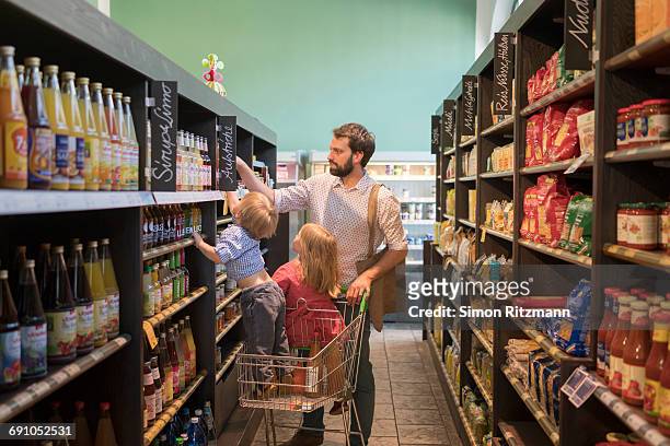 father with daughter and son grocery shopping - leanintogether stock pictures, royalty-free photos & images