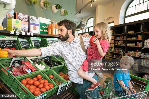 modern father with two kids shopping organic food - leanintogether stock pictures, royalty-free photos & images