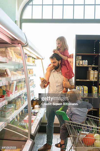 modern father with two children in grocery store - leanintogether stock pictures, royalty-free photos & images