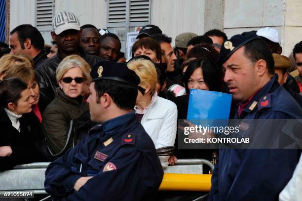 Immigrants stand in line in front of immigration offices downtown Naples in order to have their visa.