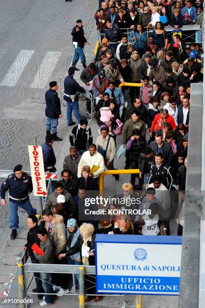 Immigrants stand in line in front of immigration offices downtown Naples in order to have their visa.