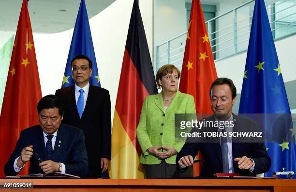 German Chancellor Angela Merkel and Chinese Prime Minister Li Keqiang look on as the chairman of the Chinese National Development and Reform...