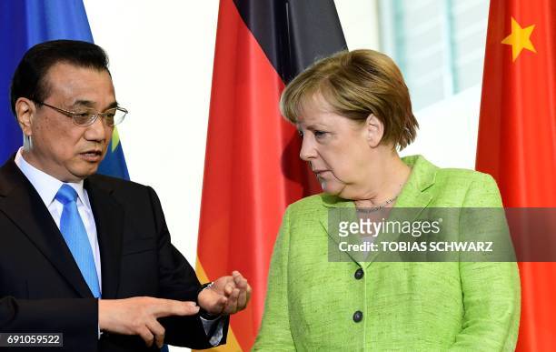 German Chancellor Angela Merkel listens to Chinese Prime Minister Li Keqiang as representatives of both countries sign economic agreements at the end...