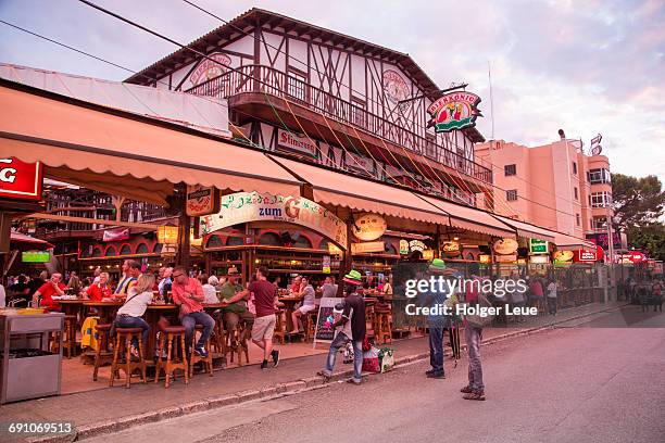 people drink and party at bierkönig beer hall - bierkönig stock pictures, royalty-free photos & images
