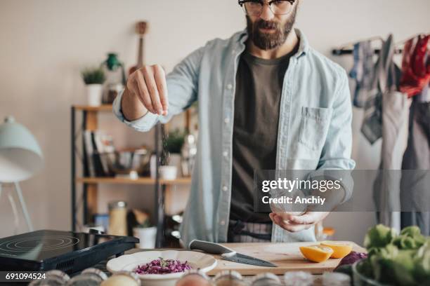 eine prise salz in einem salat - hipster in a kitchen stock-fotos und bilder