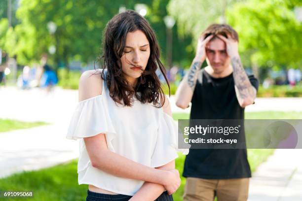 a young man is angry at his sad girlfriend - boyfriend crying stock pictures, royalty-free photos & images