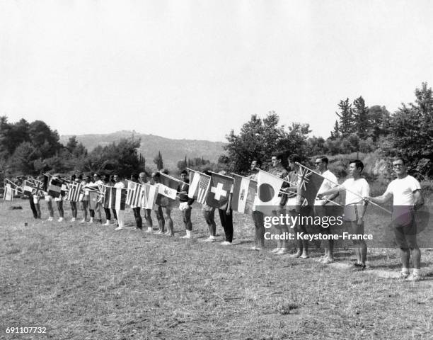 Les représentants des différents pays avec leur drapeau durant la cérémonie de clôture des Jeux olympiques, à Olympie, Grèce le 26 juin 1961.