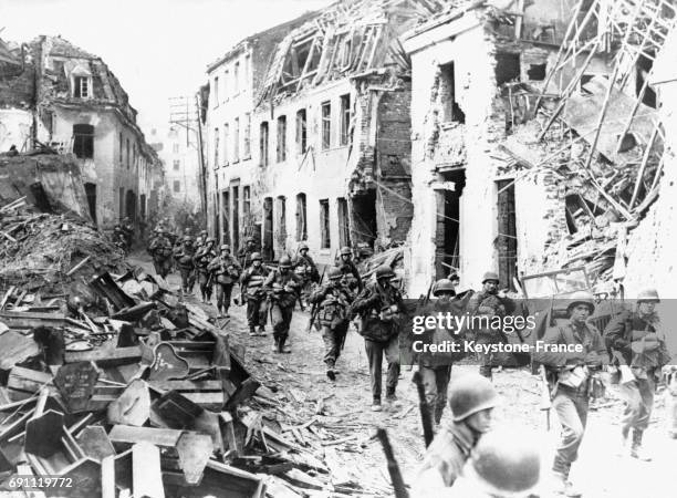 Des troupes alliées traversent une ville allemande en ruines en 1945 en Allemagne.
