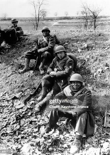 Une troupe française se repose sur un tertre après avoir passé la rivière servant de démarcation en 1945 en Allemagne.