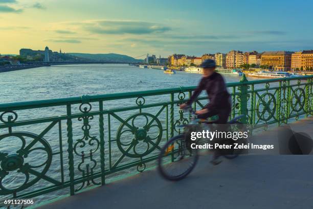 motion blurred unrecognizable cyclist on the liberty bridge in budapest, hungary - river danube stock pictures, royalty-free photos & images