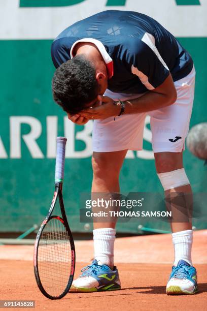 Spain's Nicolas Almagro reacts as he has to give up due to an injury during his tennis match against Argentina's Juan Martin Del Potro at the Roland...