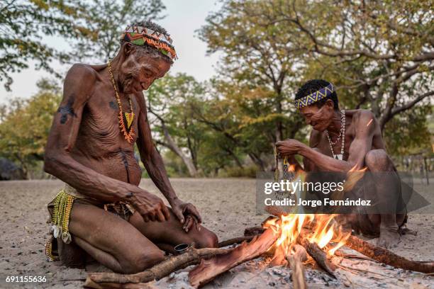 Two elders of the San tribe getting ready for a traditional dance around the fire.