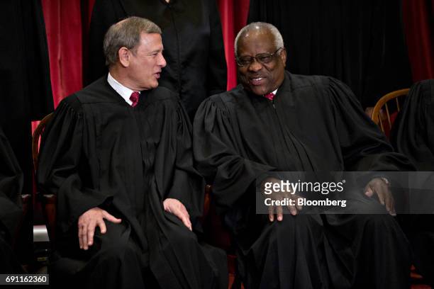Chief Justice John Roberts, left, speaks with Associate Justice Clarence Thomas, during the U.S. Supreme Court formal group photograph in the East...