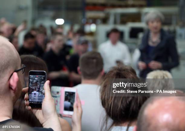 People film Conservative party leader Theresa May on their mobile phones as she delivers a speech at Ultima Furniture in Pontefract, West Yorkshire,...