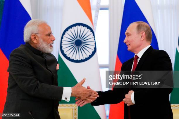 Russian President Vladimir Putin and Indian Prime Minister Narendra Modi shake hands after a signing ceremony following their meeting on the...