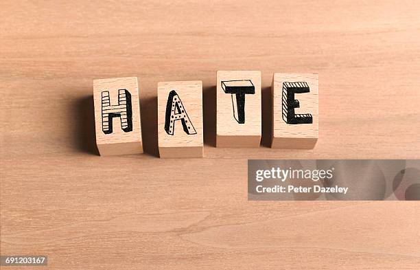 wooden bricks spelling out word hate - hate palabra en inglés fotografías e imágenes de stock