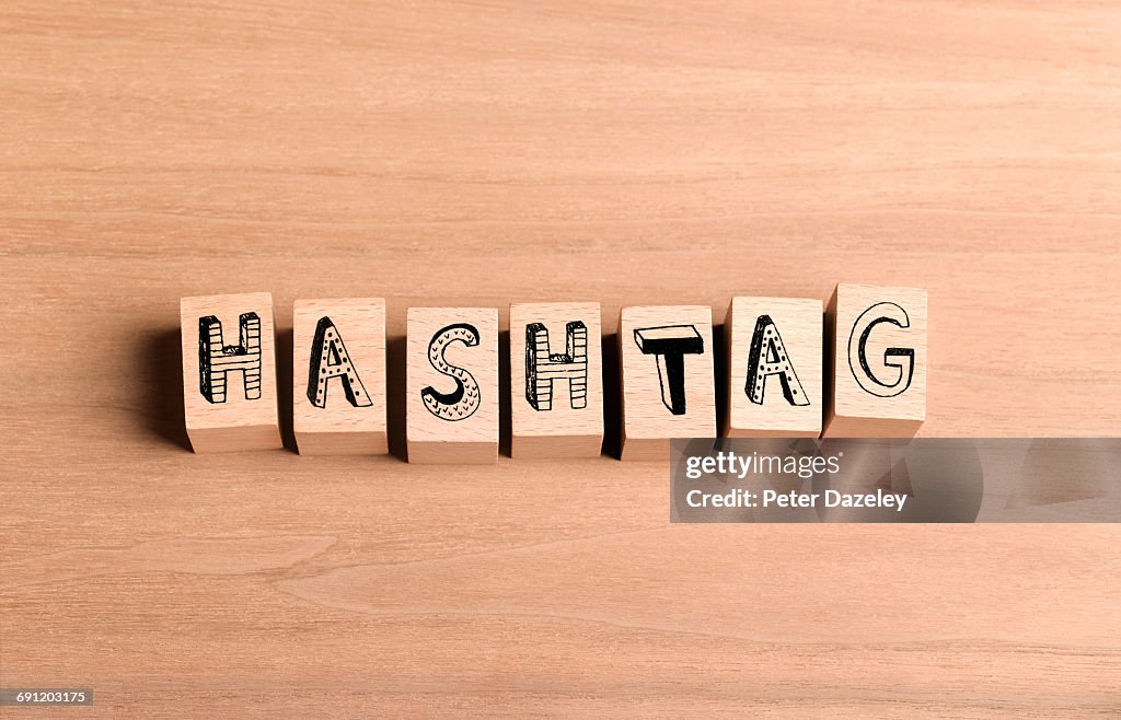 Wooden bricks spelling out word hashtag