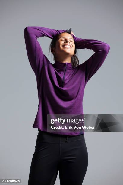 woman wearing running apparel in studio - purple pants - fotografias e filmes do acervo