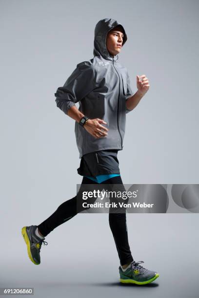 man running on grey background wearing workout apparel - abbigliamento sportivo foto e immagini stock