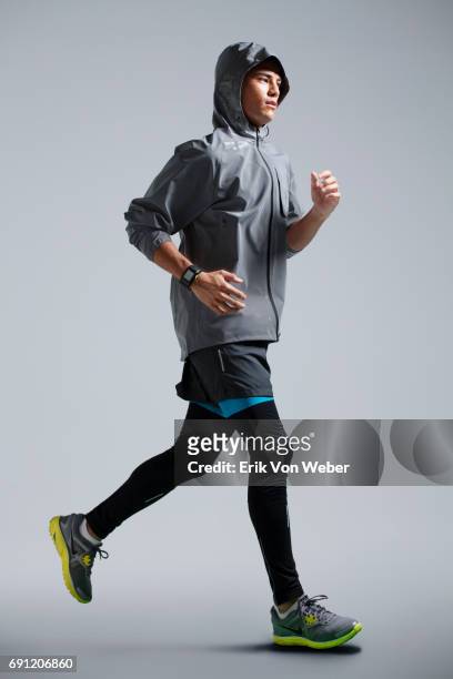 man running on grey background wearing workout apparel - sportswear stock pictures, royalty-free photos & images