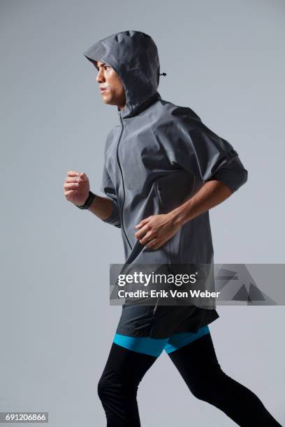 man running on grey background wearing workout apparel - レギンス　 ストックフォトと画像