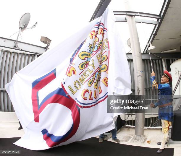 Sgt. Pepper' from The Beatles LOVE by Cirque du Soleil raising the flag of the 50th Anniversary Celebration of The Beatles' "Sgt. Pepper's Lonely...