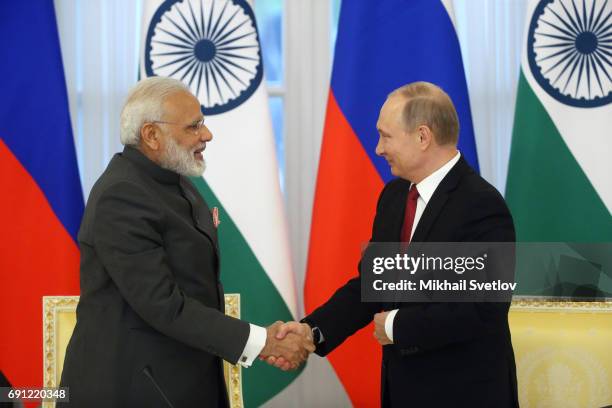 Russian President Vladimir Putin shakes hands and Indian Prime Minister Narendra Modi during their meeting at the Konstantin Palace on June 1, 2017...