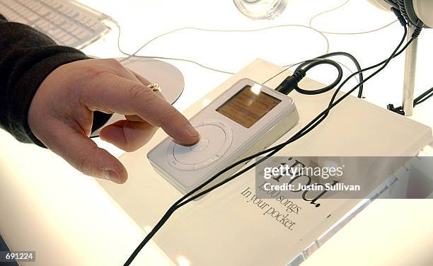 Man touches the Apple iPod mp3 music player on display during the Macworld Conference and Convention January 8, 2002 at the Moscone Center in San...