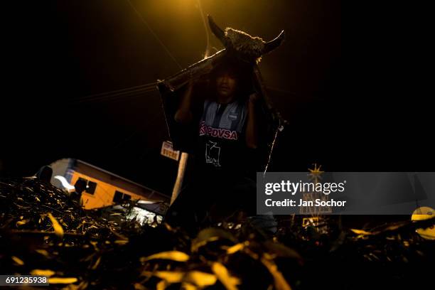 Dancer, masked as a bull, performs during the night before the religious festival of Corpus Christi in Pujili on May 31, 2013 in Pujili, Ecuador....