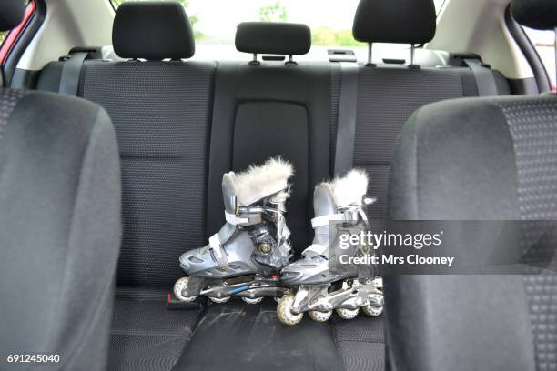 roller skates on the back seat of a family car - back seat stock pictures, royalty-free photos & images